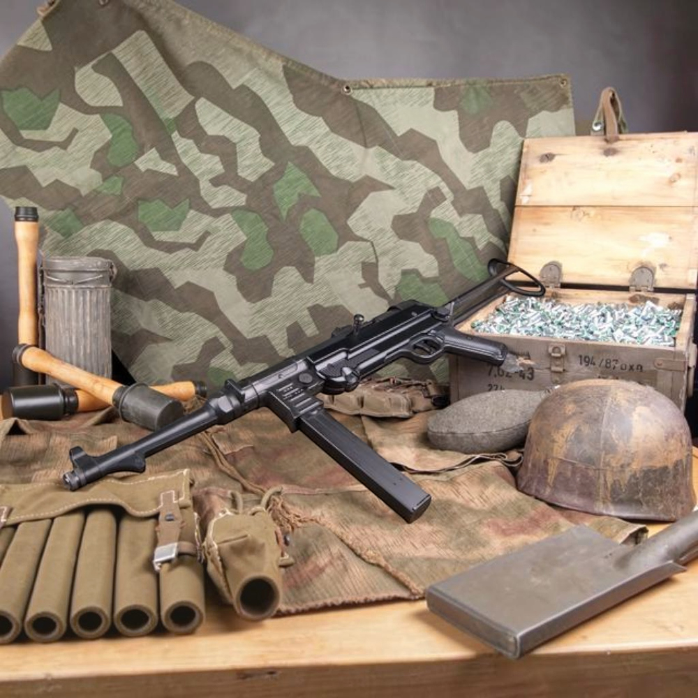 id-paintball GSG MP40 Schreckschusswaffe in Schwarz mit klappbarer Schulterstütze auf historischem Militär-Equipment
