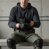 id-paintball MECHANIX Original Handschuhe in Schwarz, getragen von einem Mann in taktischer Ausrüstung.