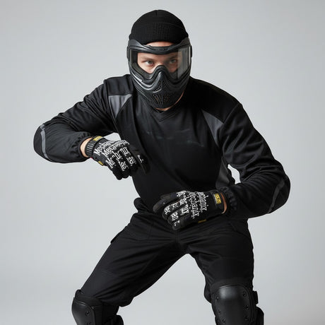 id-paintball Mechanix The Original Einsatzhandschuhe in Schwarz mit weissem Logo, getragen von einem Paintball-Spieler.