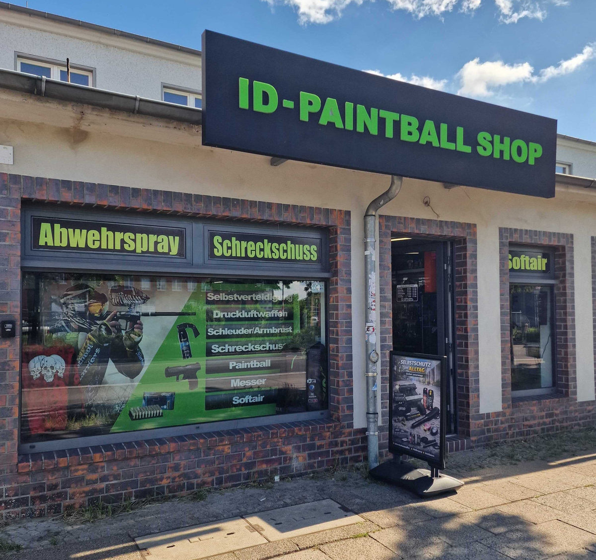 Außenansicht des ID-Paintball Shops in Berlin mit Ladenschild und Schaufenster für Paintball, Softair und Selbstverteidigung.