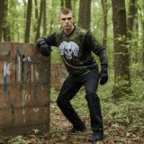 id-paintball The Skulls Paintball Trikot in Oliv mit Schulterpolsterung, getragen von einem Spieler im Wald