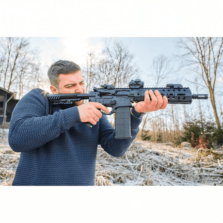 id-paintball UX Strike Force CO2-Sportgewehr im AR-Design mit Blowback, gehalten von einem Mann im Freien.